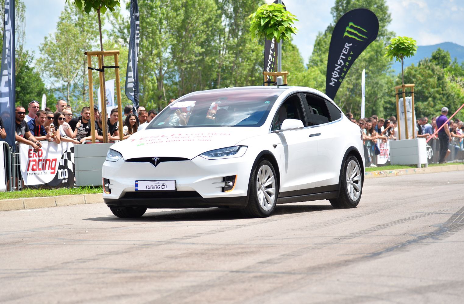 White electric SUV with sleek design at racing event
