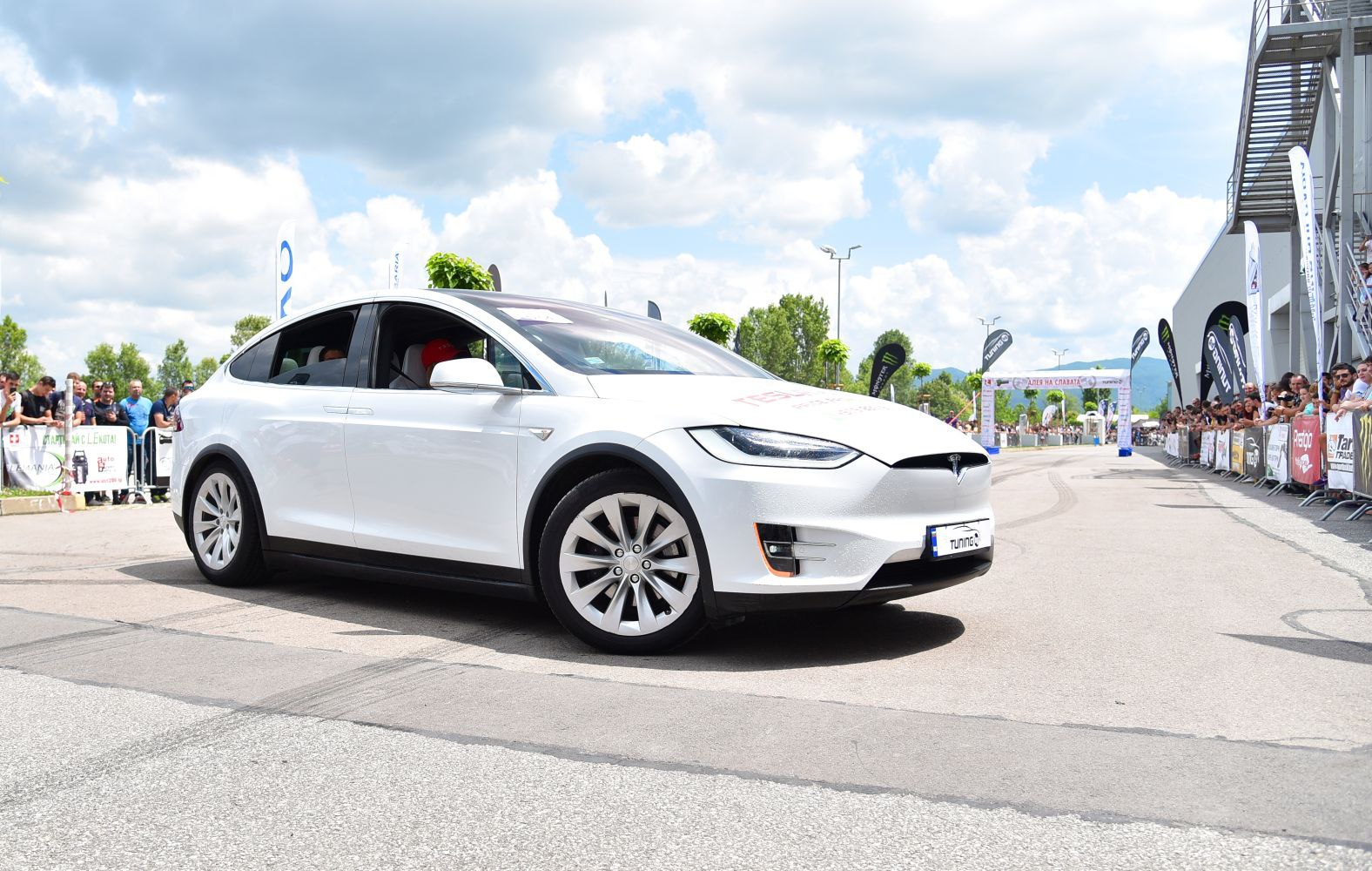White electric SUV with falcon wing doors and sleek aerodynamic shape