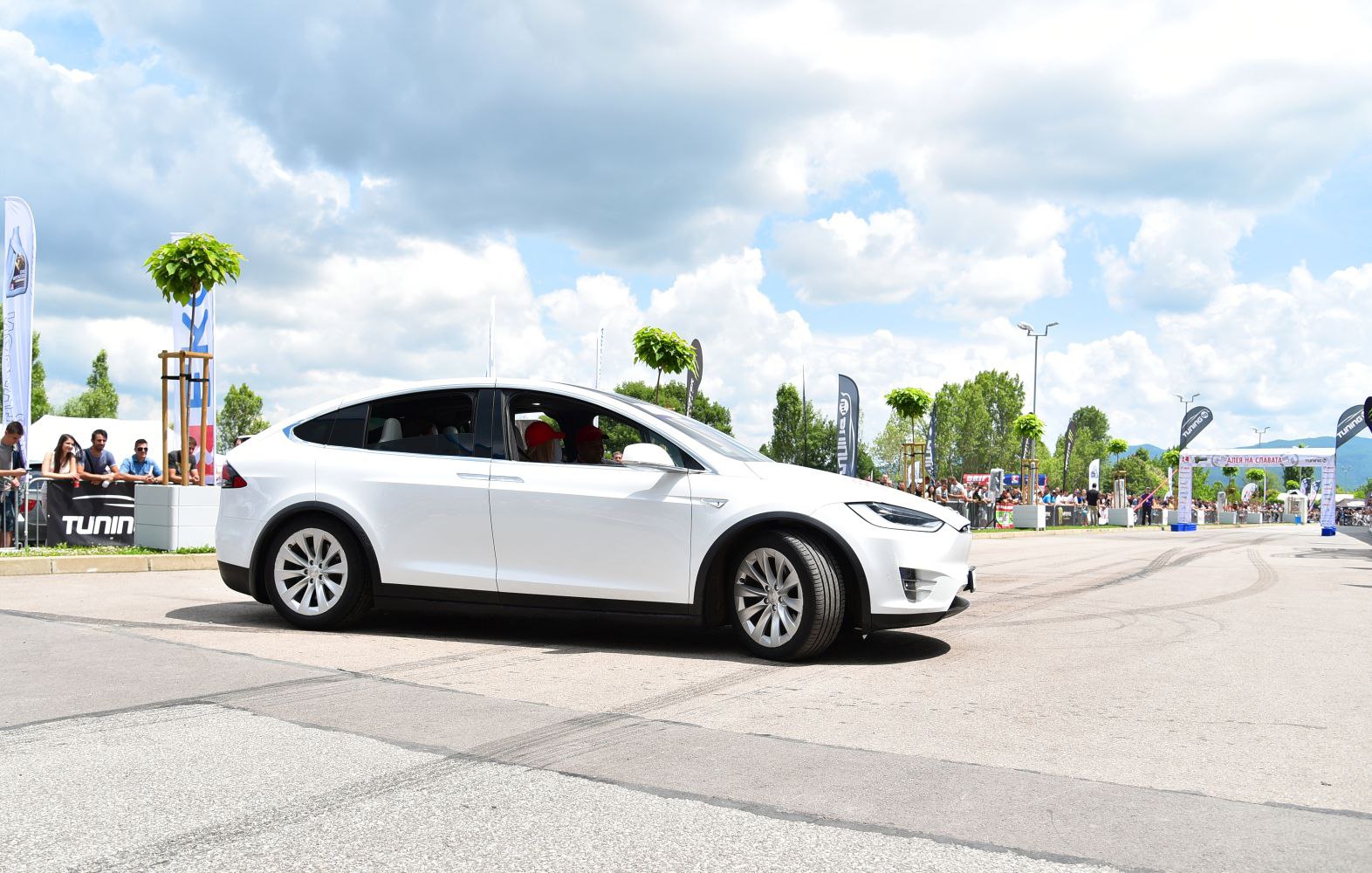 White electric SUV side profile, alloy wheels, outdoor event