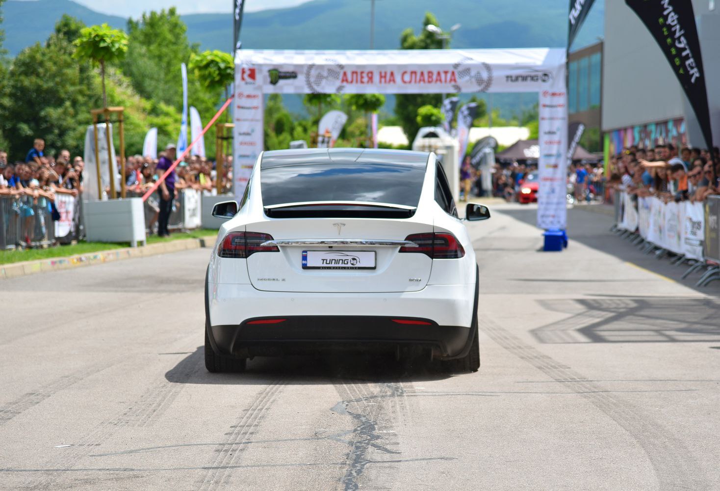 Rear view of white electric SUV with prominent taillights and roofline.