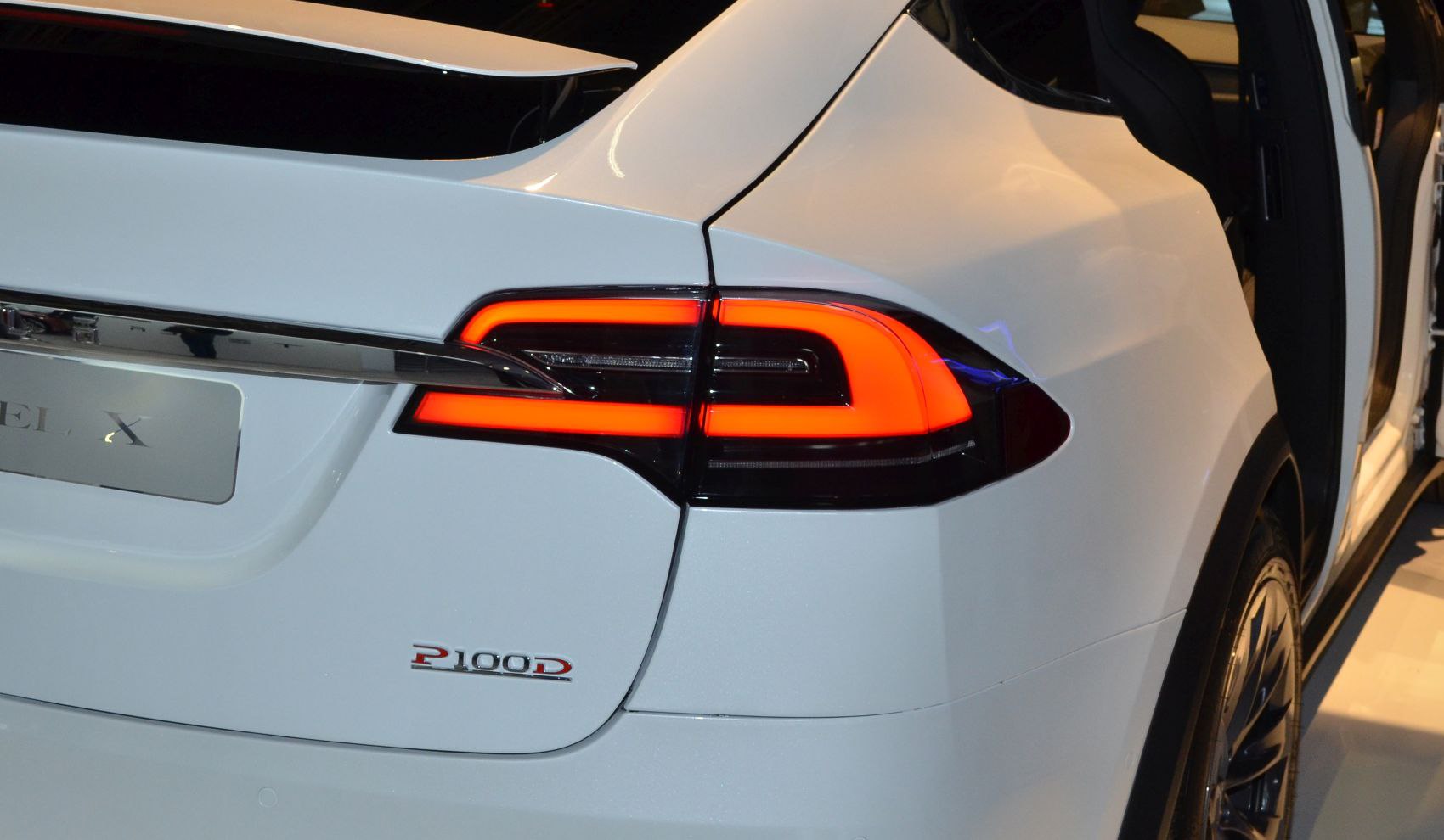Close-up of rear tail light and P100D badge on white SUV