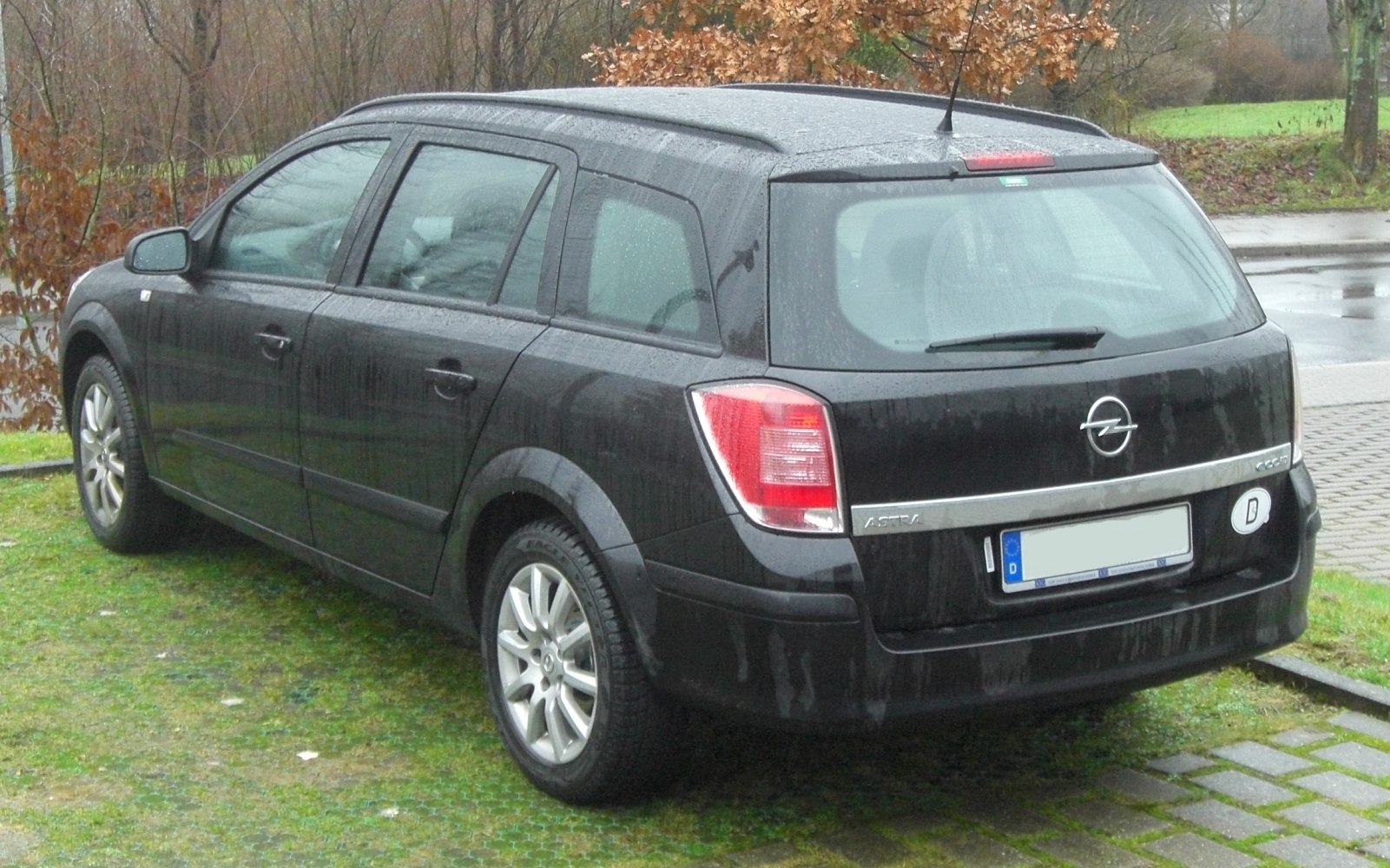 Rear and side view of black station wagon with tail lights and alloy wheels