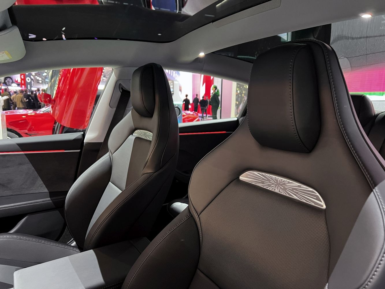 Sporty front seats with panoramic glass roof in modern electric car interior