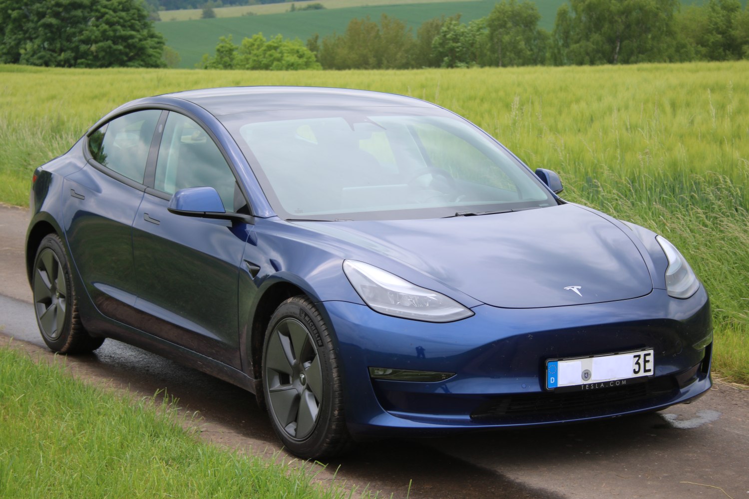 Front side view with aerodynamic headlights and matte black wheels
