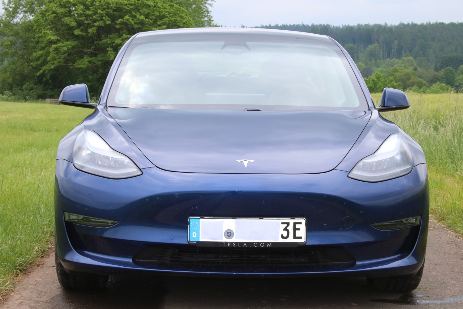 Front view of sleek electric sedan with distinctive headlights and aerodynamic design