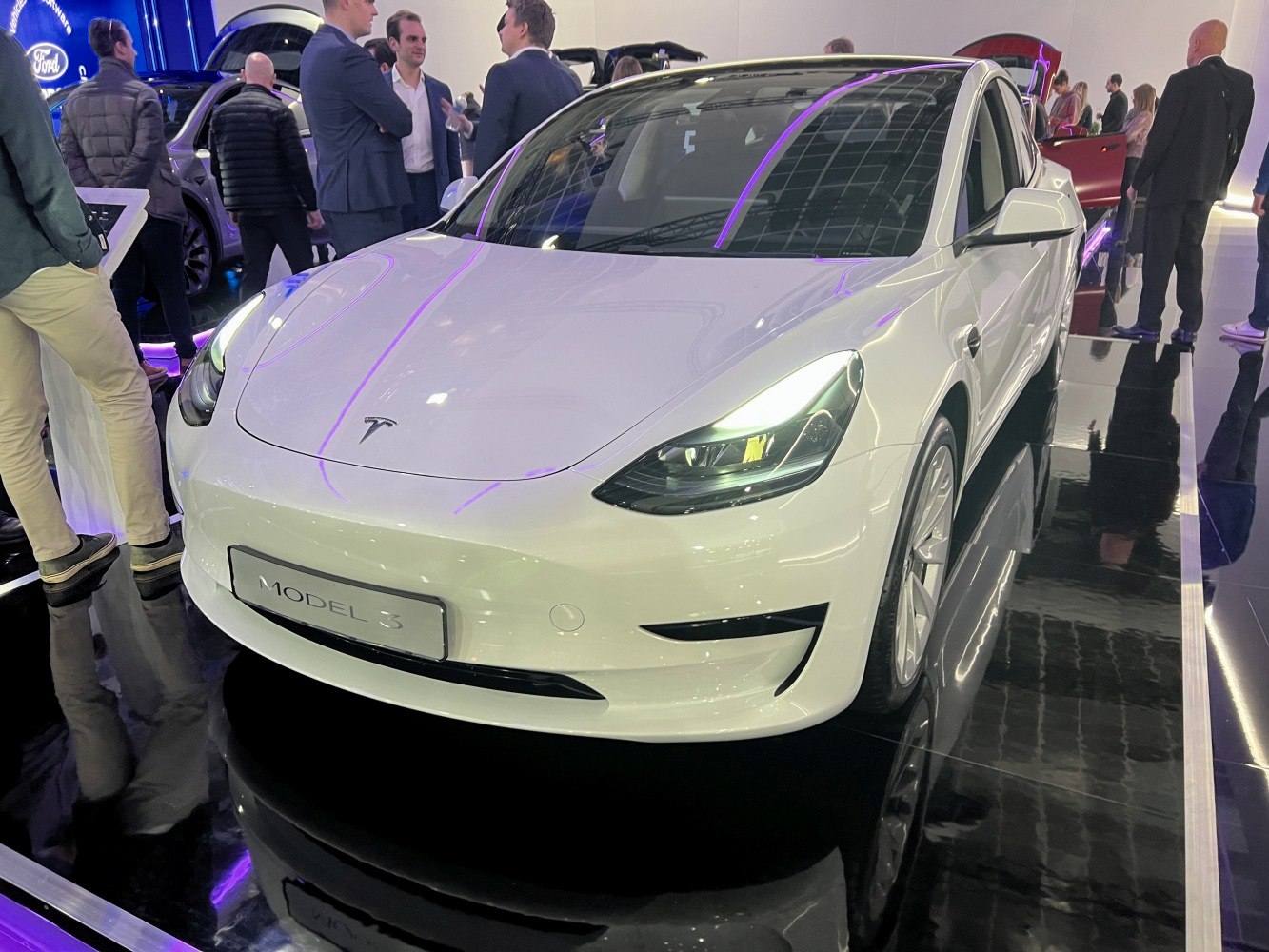 White electric sedan with sleek LED headlights and smooth body contours.