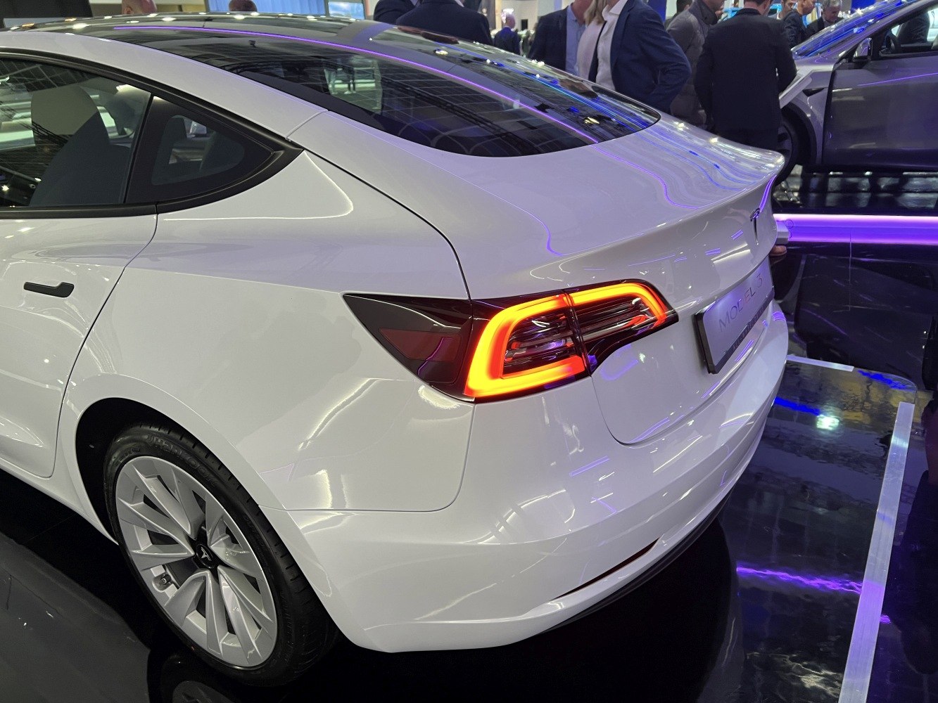 Rear view of a white electric sedan with LED taillights and aerodynamic design