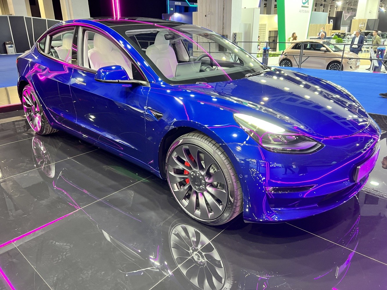 Front three-quarter view of electric sedan with sleek headlights and sporty alloy wheels