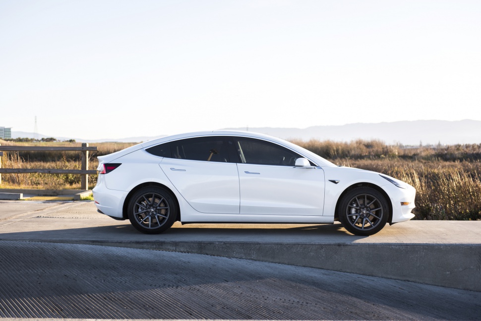 Side view of sleek white electric sedan with tinted windows and alloy wheels