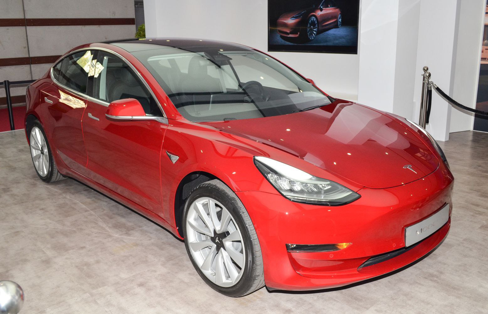 Red electric sedan with sleek headlights and alloy wheels