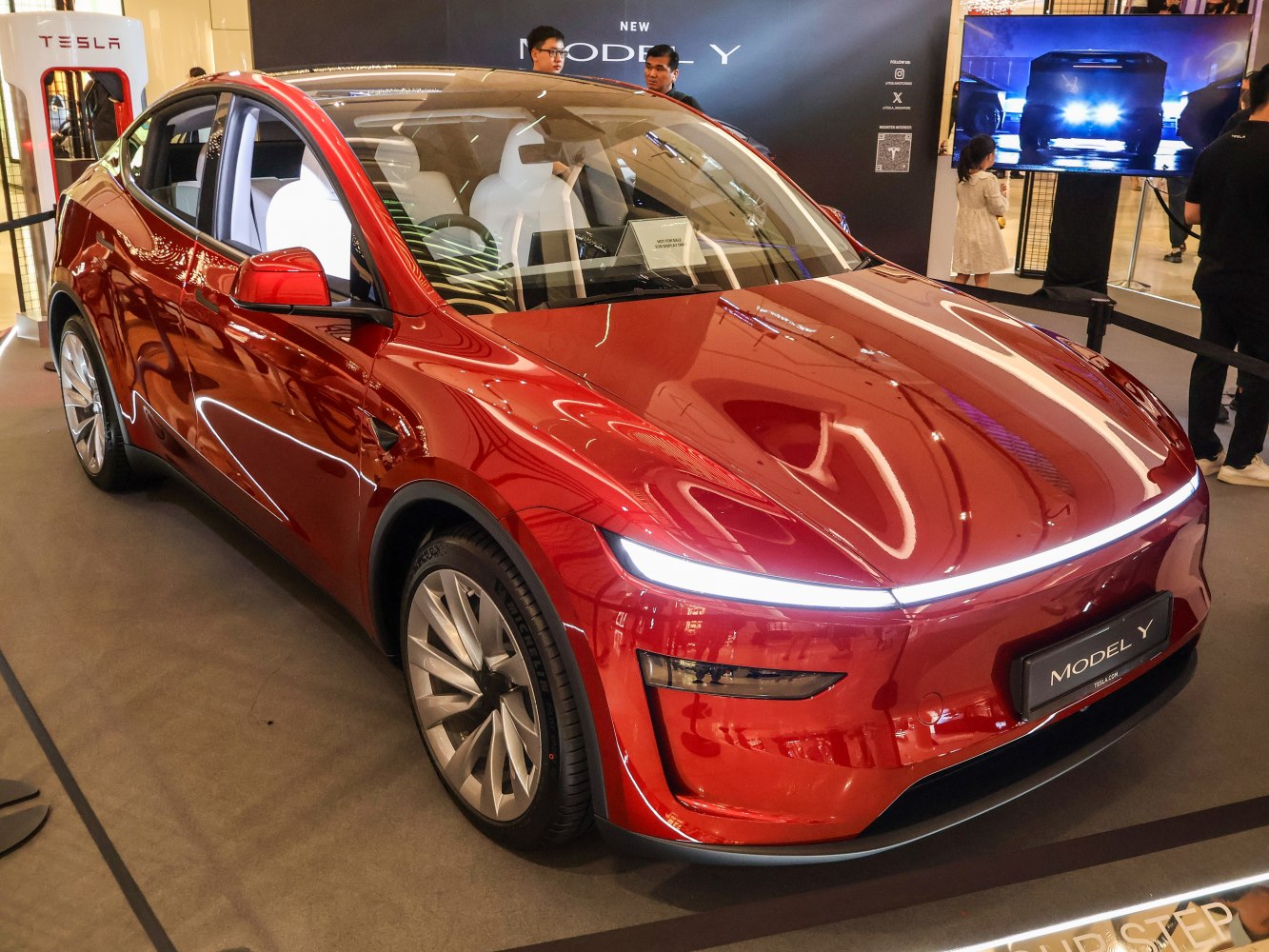 Sleek red electric SUV with aerodynamic design and LED front light bar