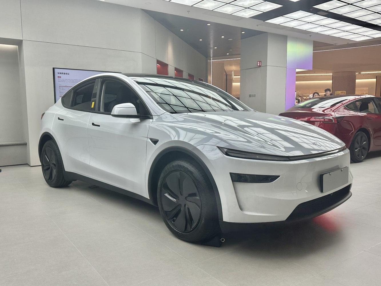 Front 3/4 view of a white electric SUV with aerodynamic wheels