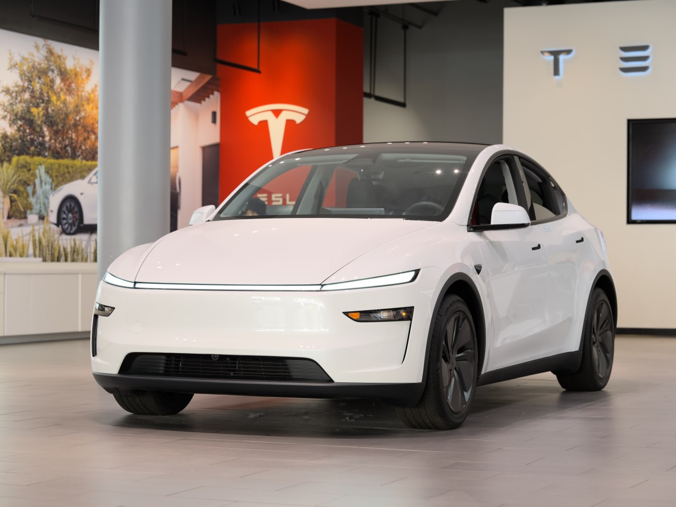 White electric SUV with continuous LED light bar and aerodynamic wheels.