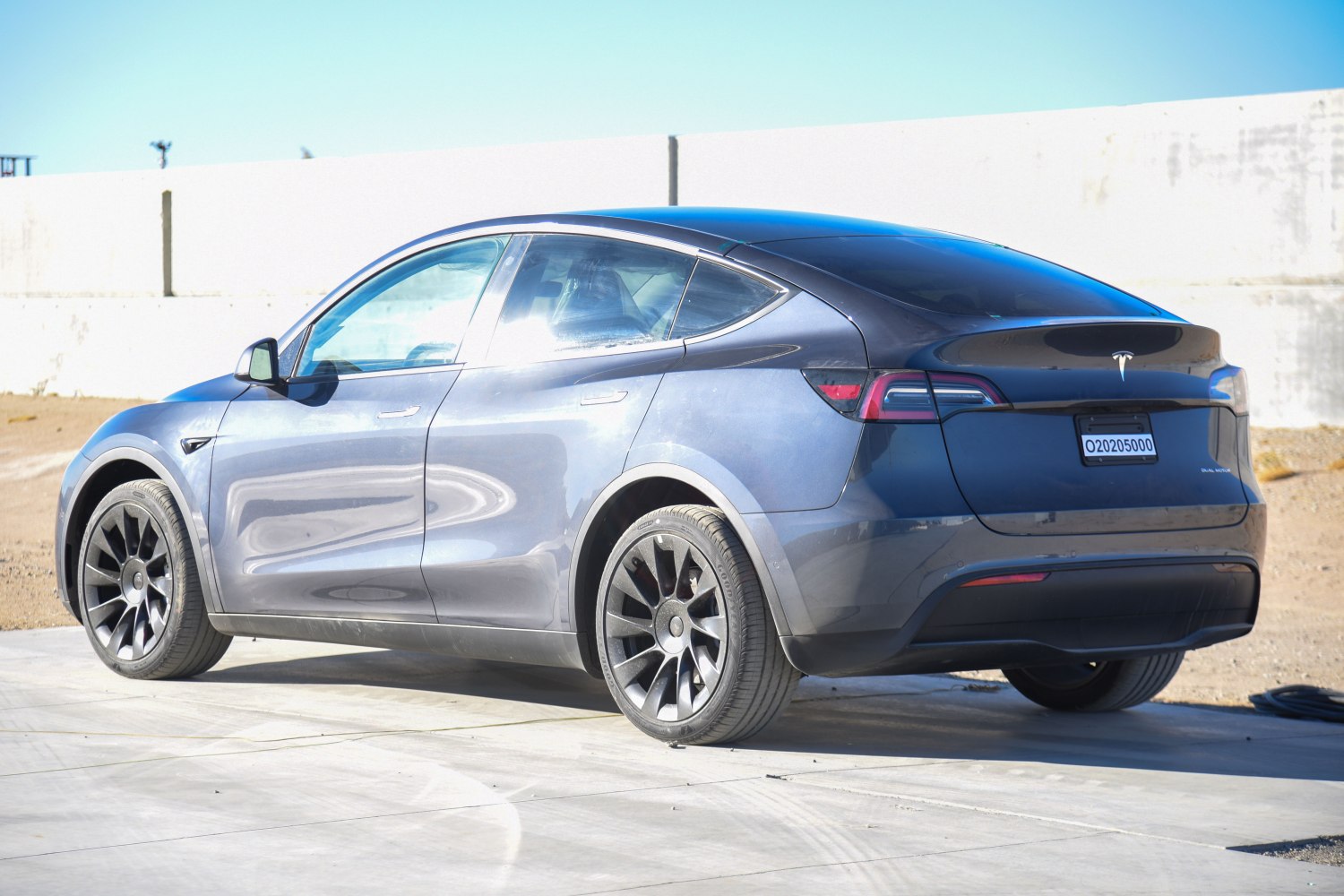 Rear side view of sleek aerodynamic electric crossover with black wheels