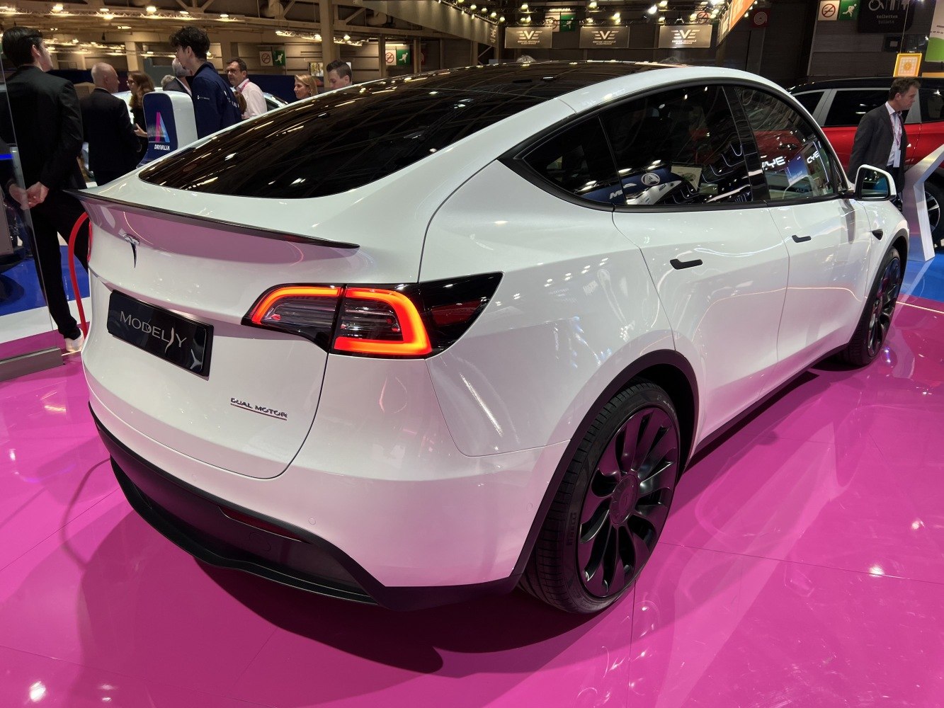 White electric SUV rear view with illuminated taillights and dual motor badge