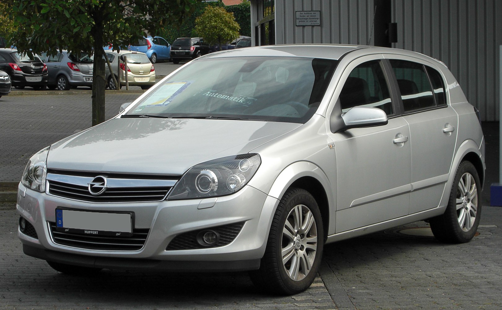 Front view of a silver hatchback with detailed headlights and grille.
