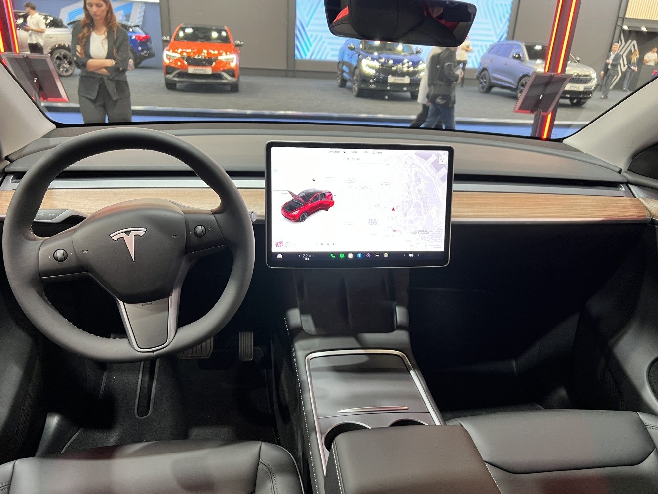 Minimalist dashboard and large touchscreen display with Tesla steering wheel.