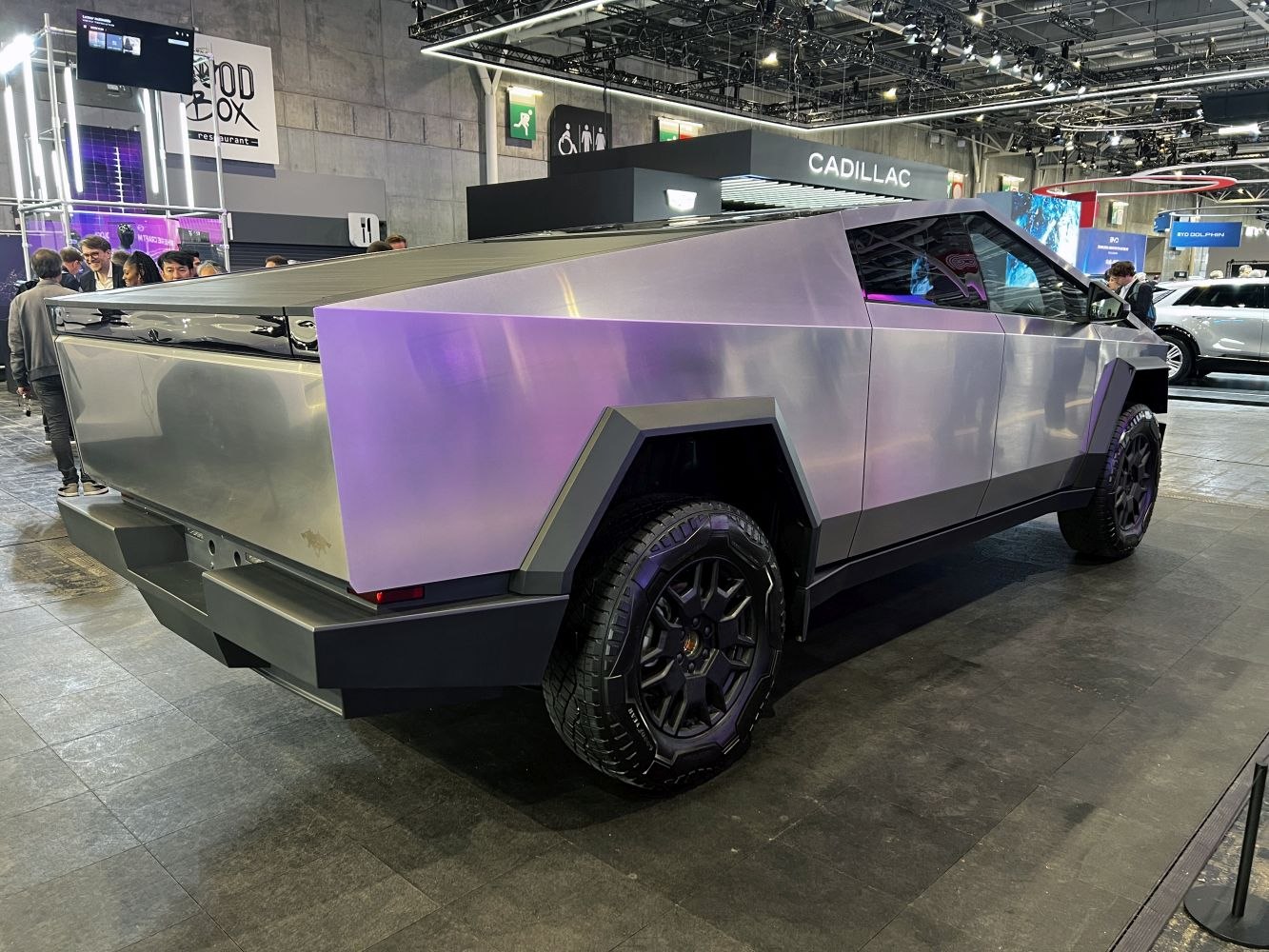 Futuristic angular metallic electric pickup truck with rugged tires.