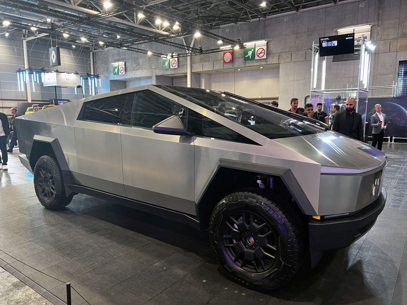 Futuristic angular electric pickup featuring matte metal finish and rugged off-road tires