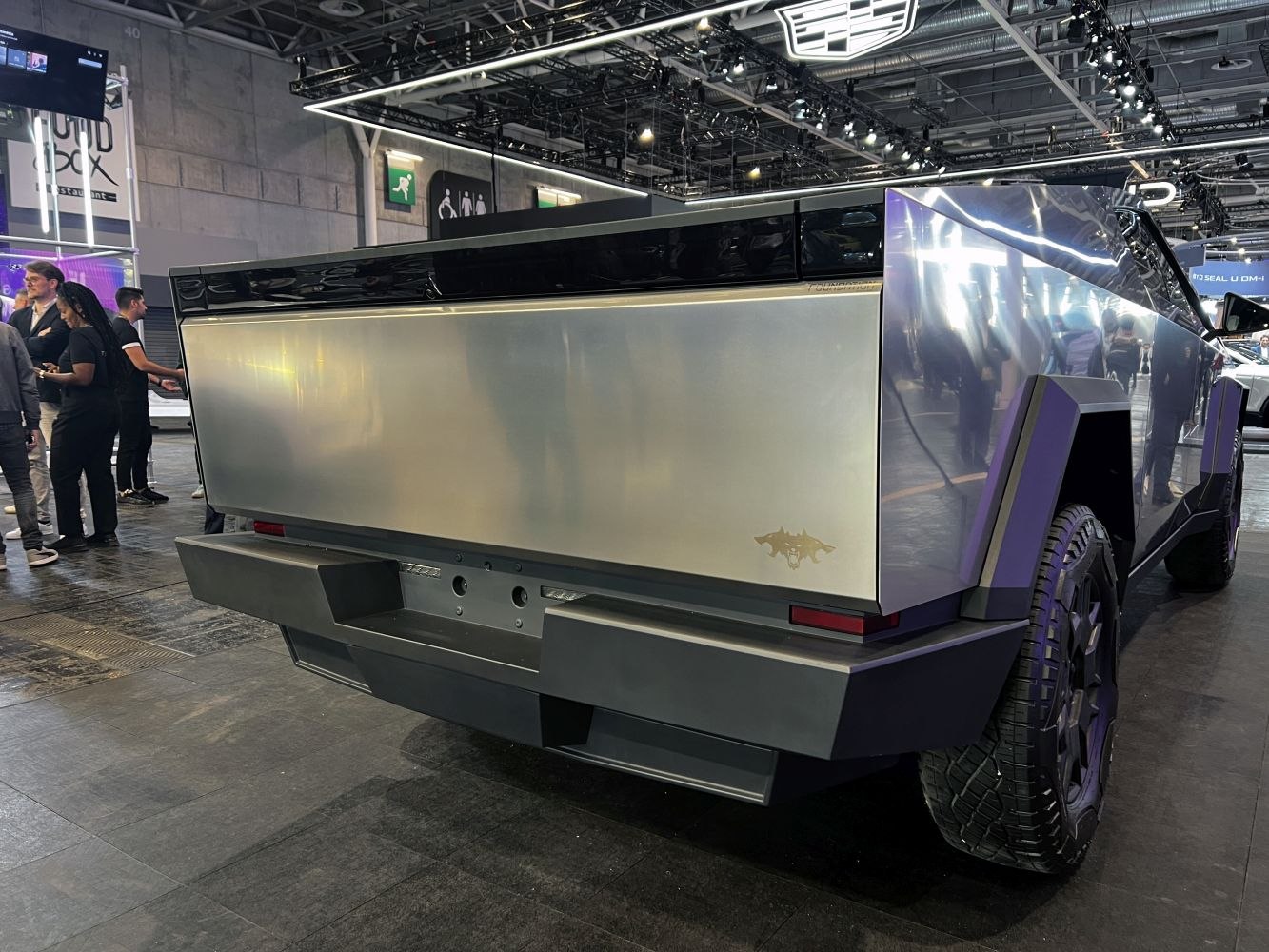 Futuristic pickup truck rear with angular steel panels and rugged tires