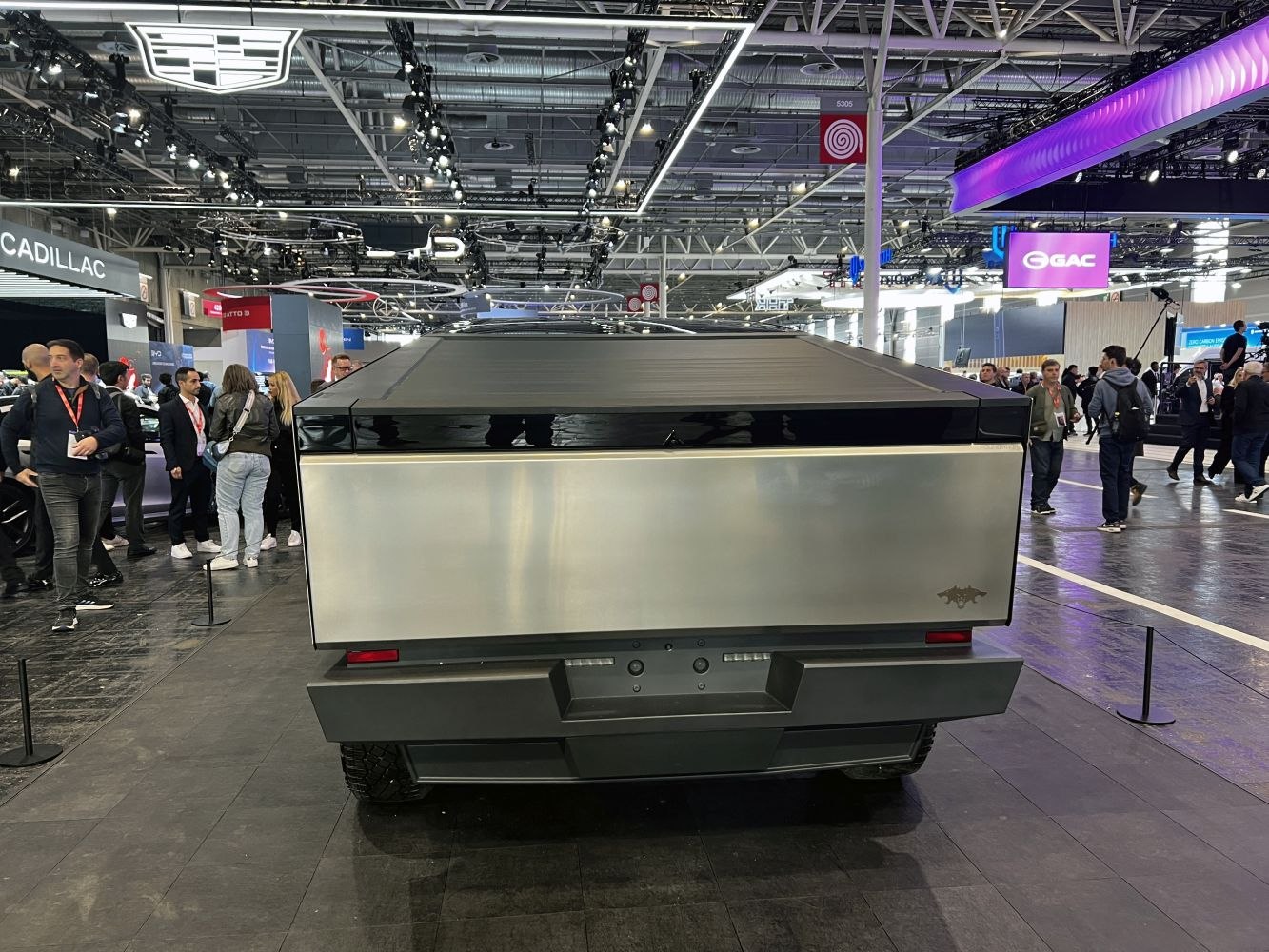 Rear view of an electric pickup truck with a covered bed and flat steel tailgate