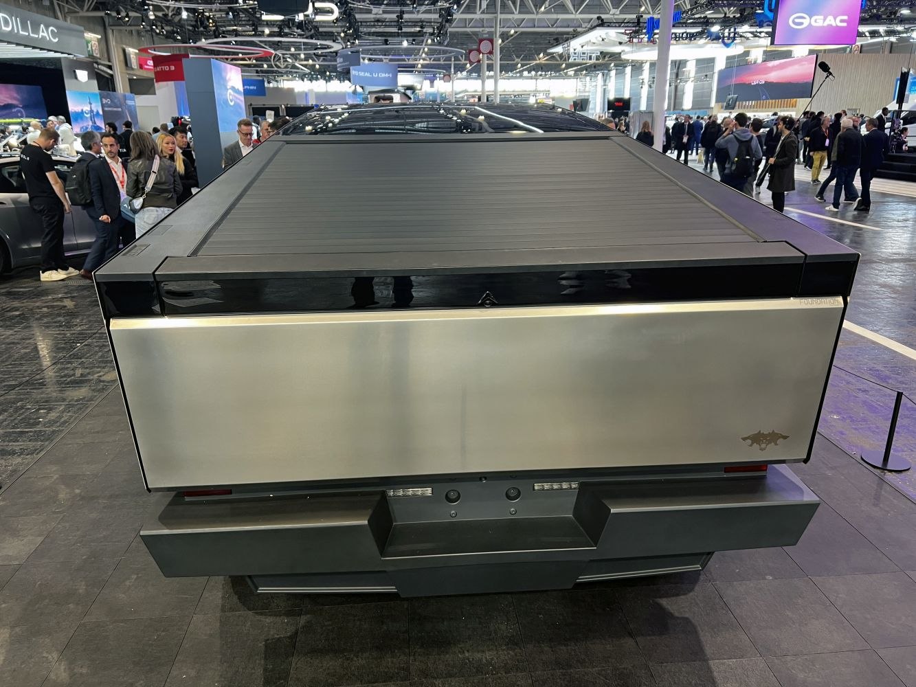Rear view of a truck with a covered bed and angular, futuristic design