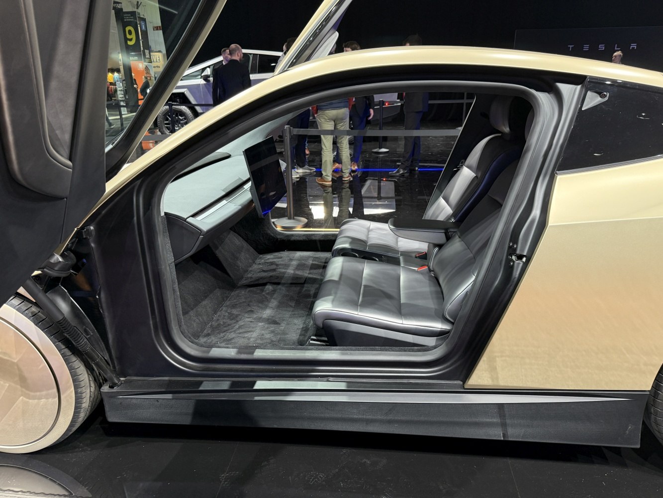 Rear passenger seats with gull-wing door in futuristic electric vehicle.