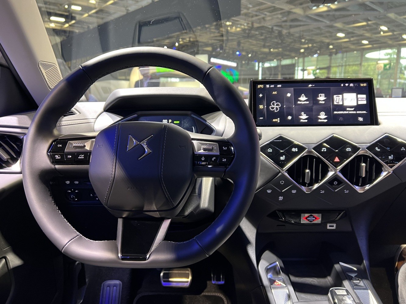 Modern steering wheel with multi-function buttons and digital touchscreen dashboard.
