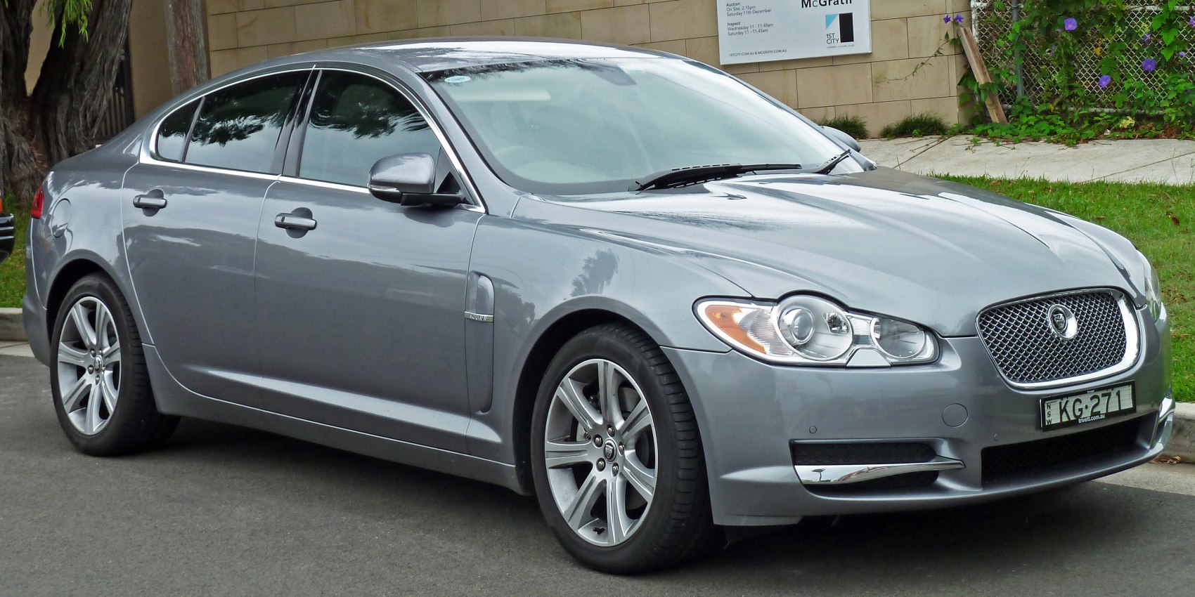 Front side view of a gray luxury sedan with alloy wheels.