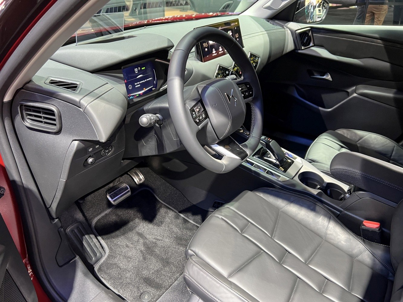 Modern car interior with digital displays, steering wheel, and leather seating