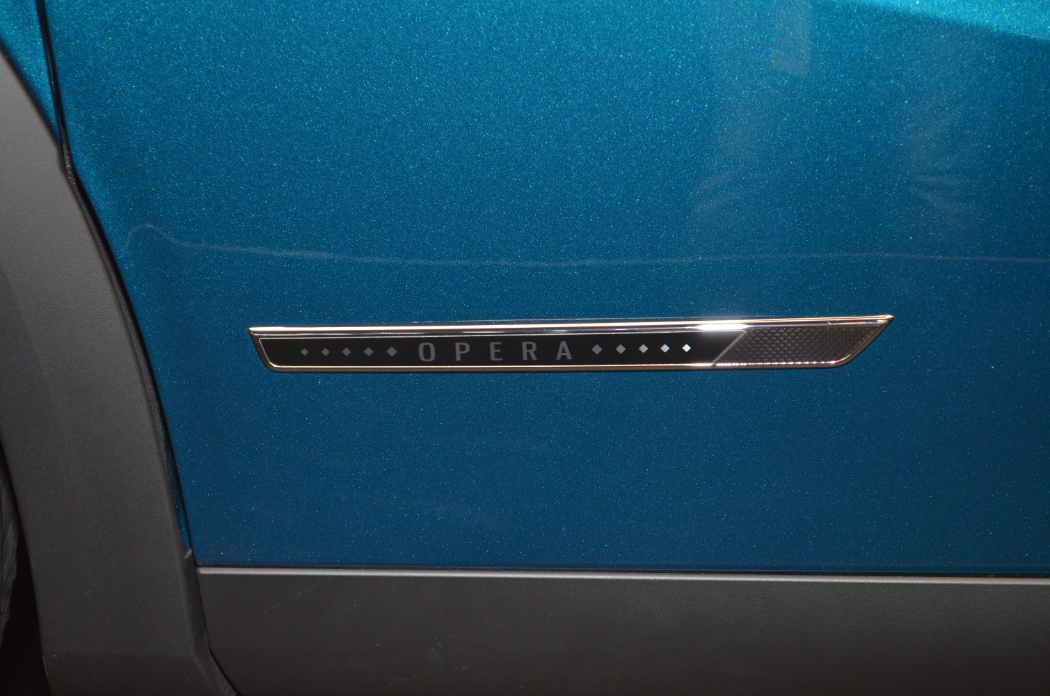 Close-up of Opera trim badge on car door side panel