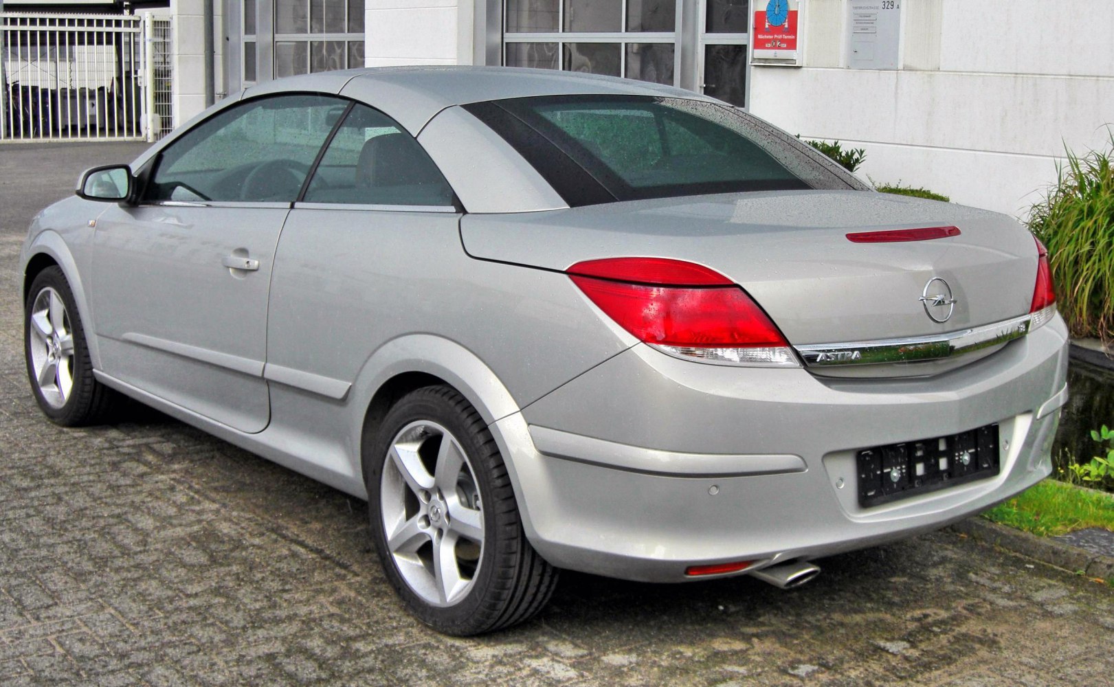 Rear view of silver convertible with distinct tail lights and hardtop roof