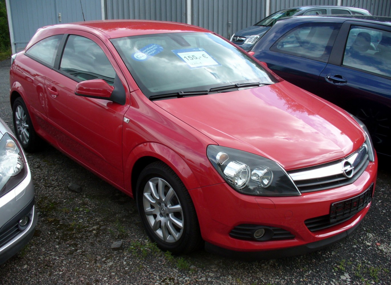 Red 3-door hatchback with alloy wheels and dual headlights