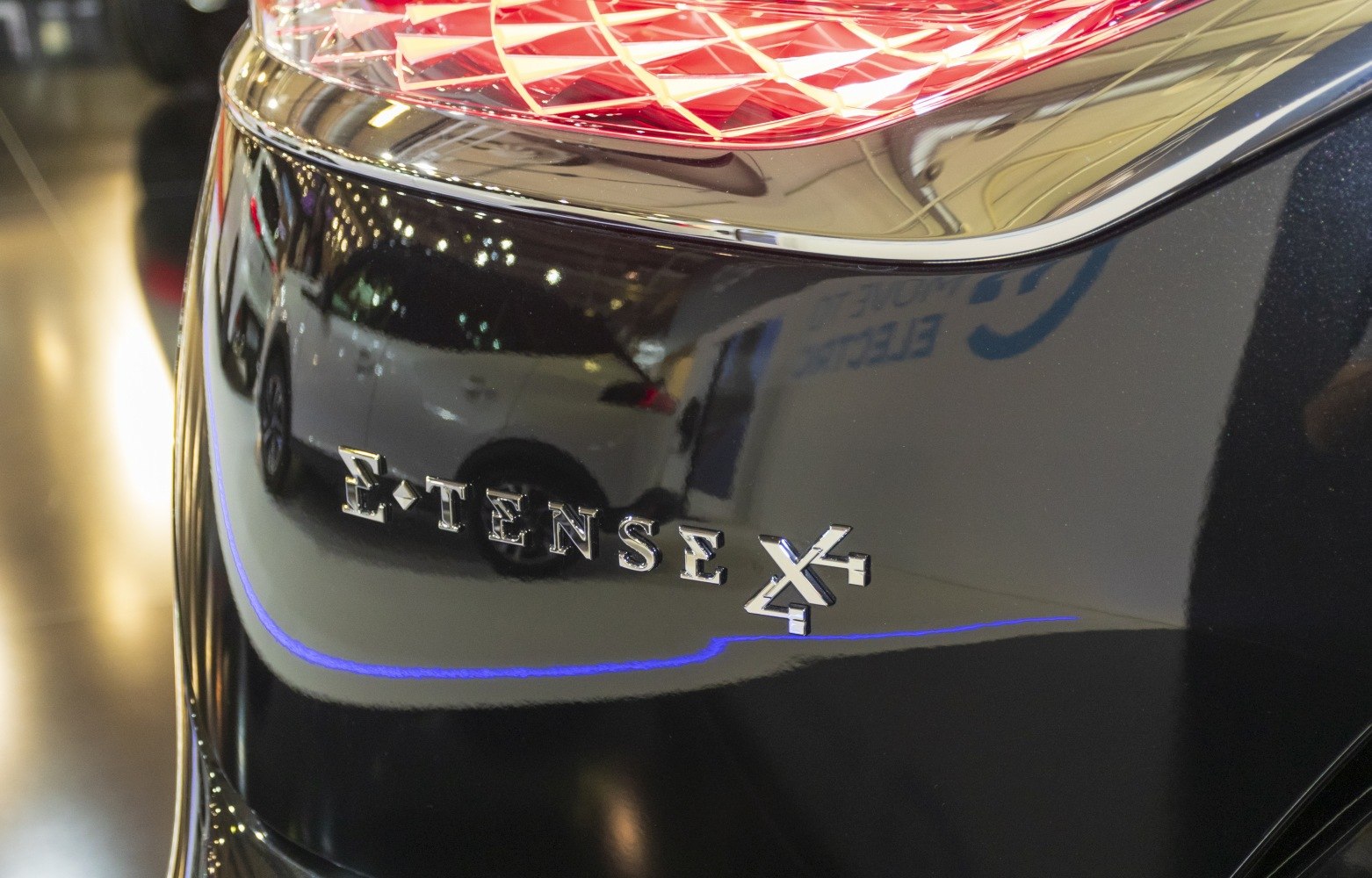 Close-up of E-Tense 4x4 badge and taillight on glossy black surface