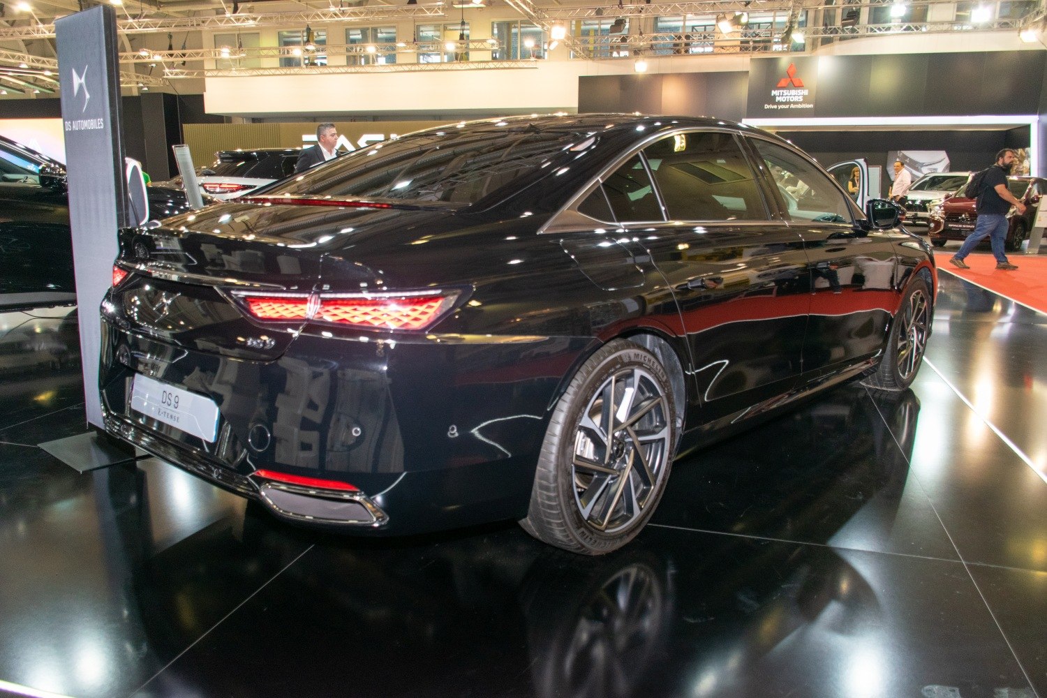 Black luxury sedan rear with LED tail lights and alloy wheels