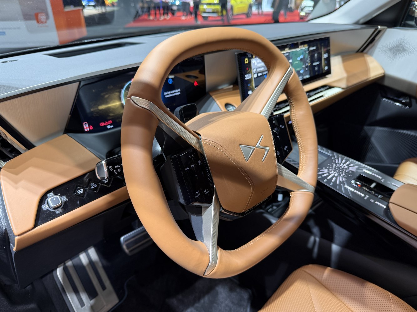 Tan leather luxury steering wheel with digital dashboard and modern controls