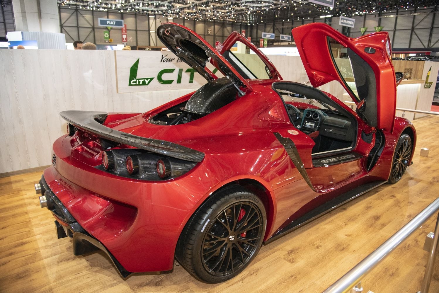Scissor doors open with sporty rear spoiler and black multi-spoke wheels