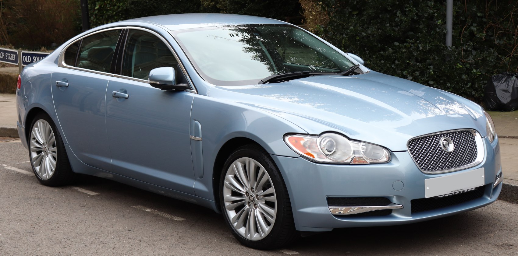 Front side view of luxury sedan with distinctive headlights and signature grille