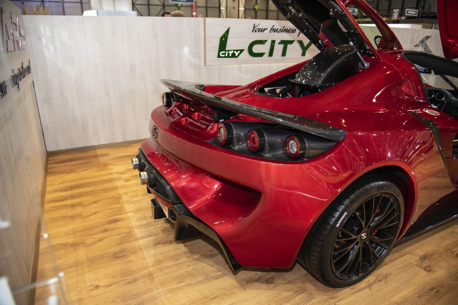 Rear view with carbon fiber spoiler, triple round taillights, and quad exhaust