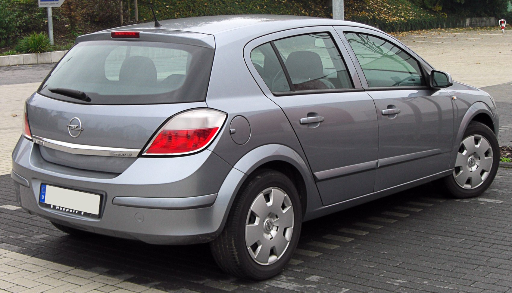 Rear and side view of a grey hatchback with distinctive tail lights and wheel covers