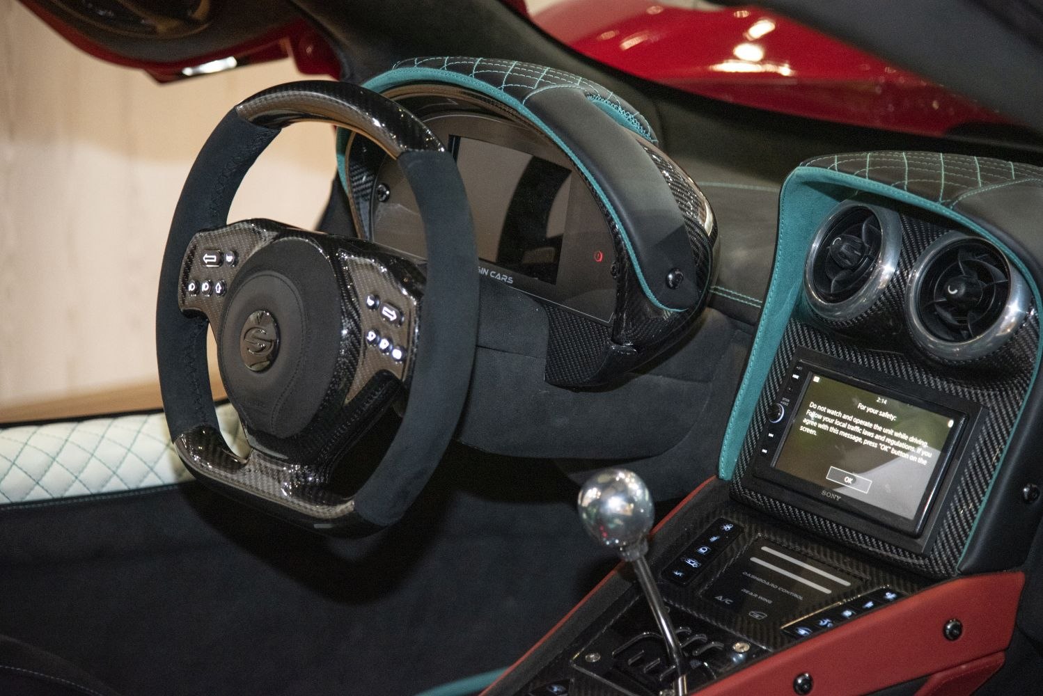 Carbon fiber steering wheel, digital display, manual gear shifter.