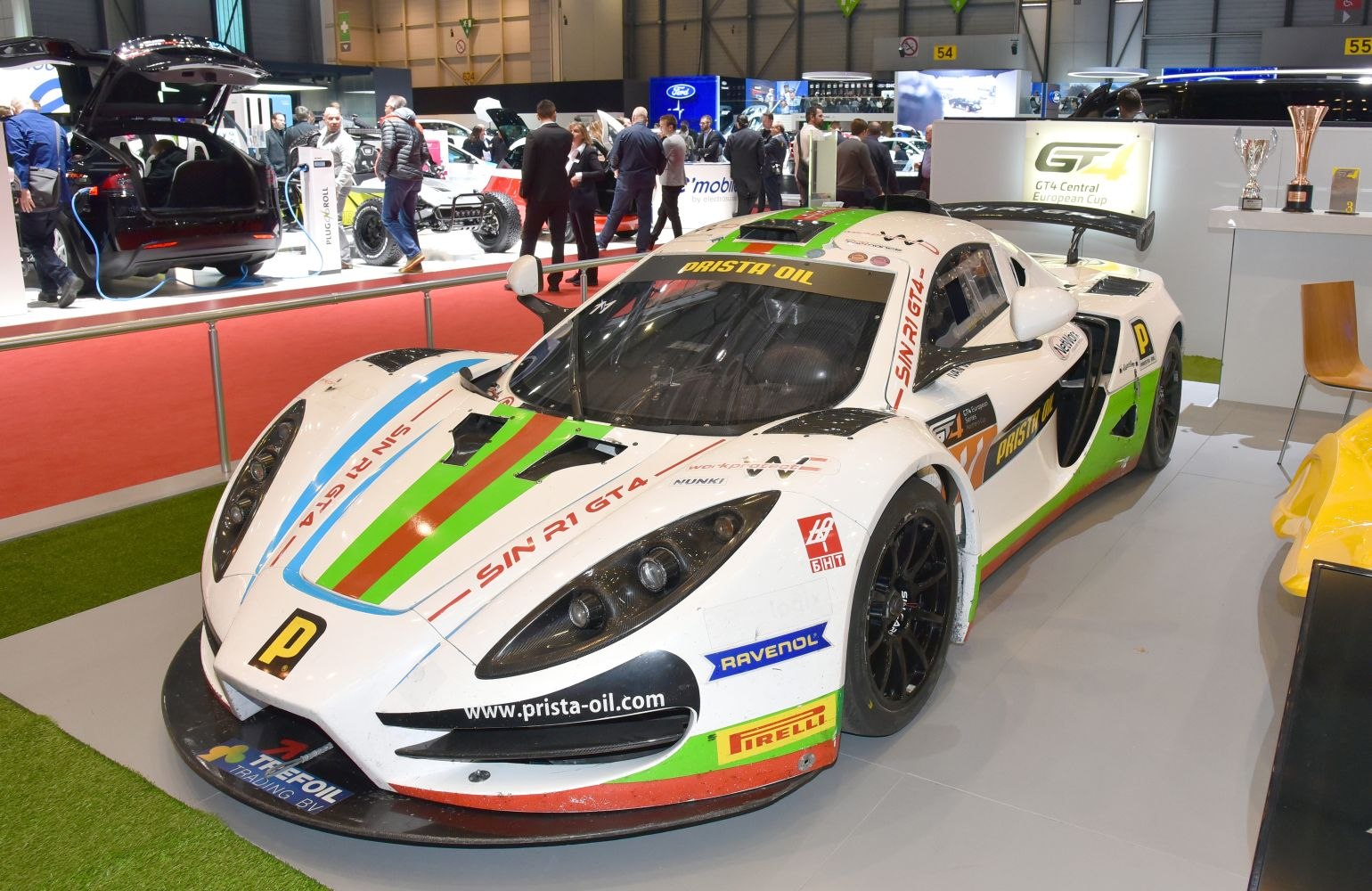 Aerodynamic race car with racing livery and prominent front splitter.