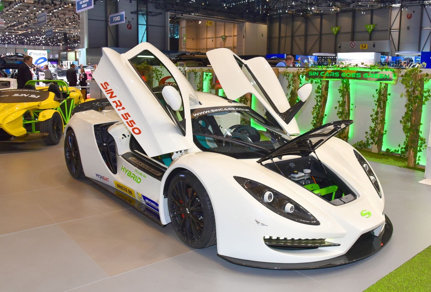 White hybrid sports car with open butterfly doors and hood revealing front trunk