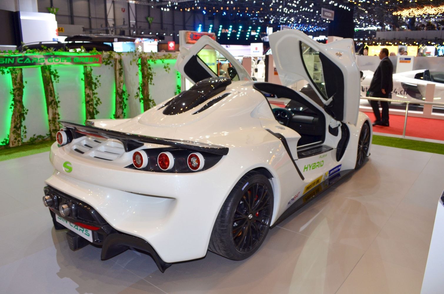 White sports car with scissor doors and rear spoiler