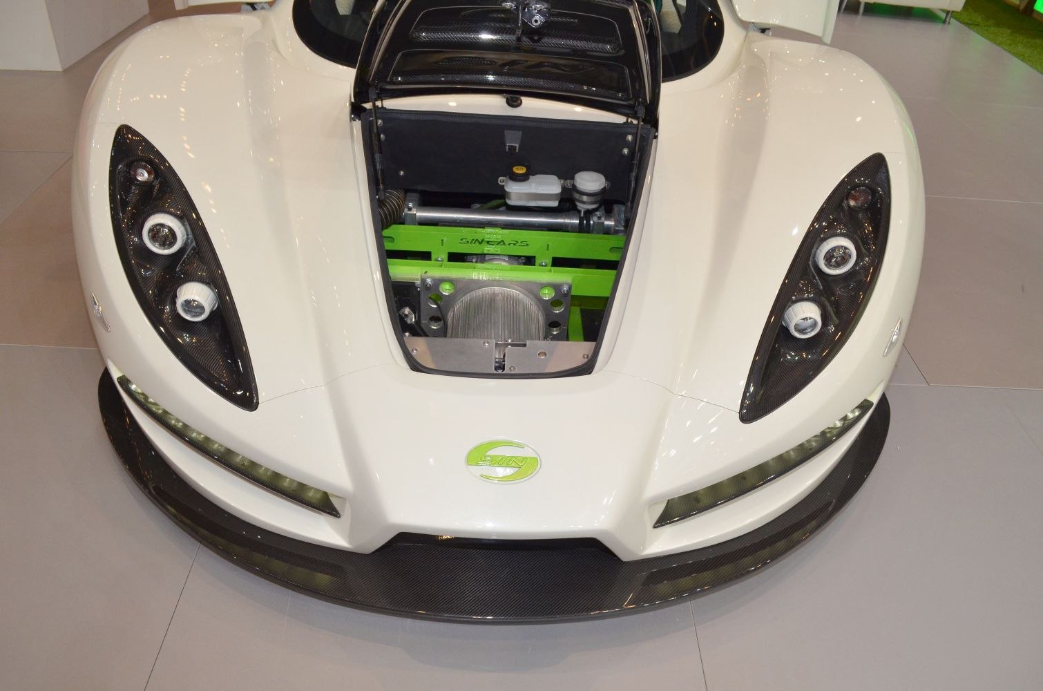 Front view with distinctive headlights and open hood showing engine frame