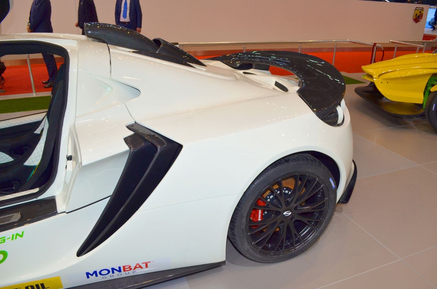 Rear carbon fiber air intakes and aerodynamic wing with black alloy wheel and red caliper