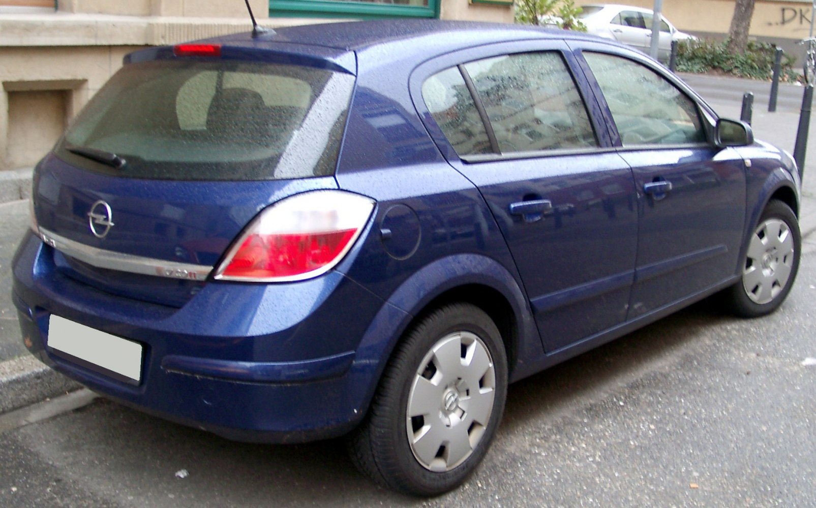 Rear of blue five-door hatchback with distinctive taillights and wheel covers