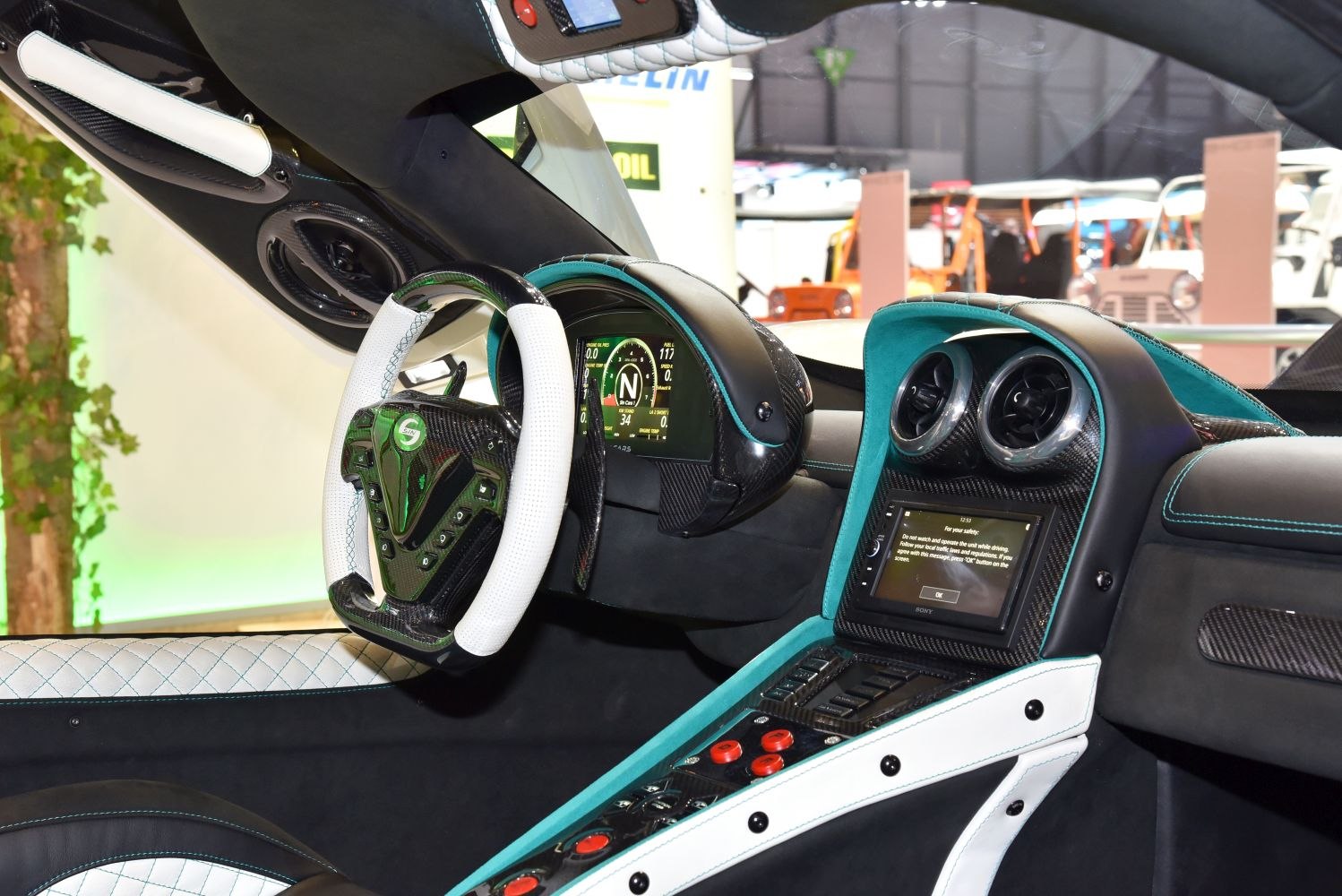 Futuristic dashboard and steering wheel with digital displays and carbon fiber accents