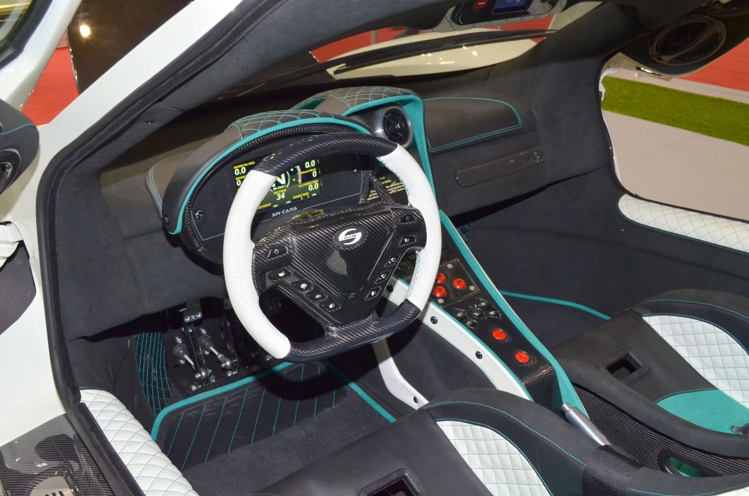 Carbon fiber steering wheel with digital dashboard and quilted leather seats.