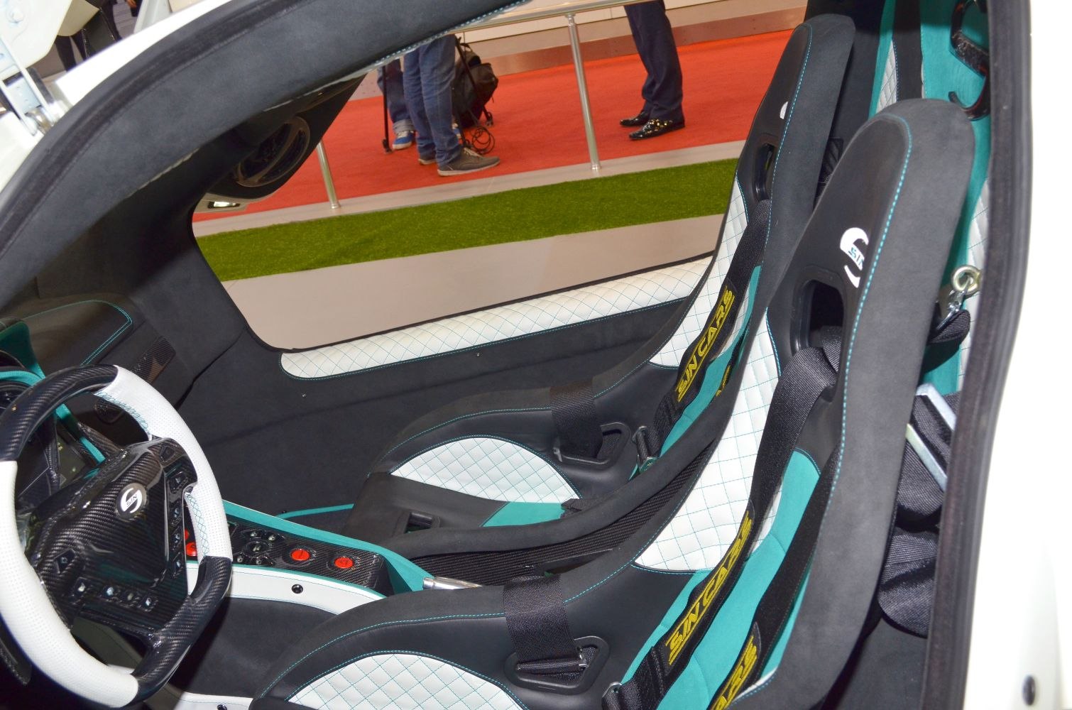 Racing bucket seats with harnesses and carbon-fiber steering wheel